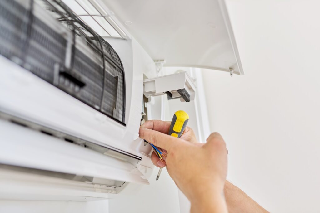 Installing an air conditioner in an apartment office, close up of an engineer hand